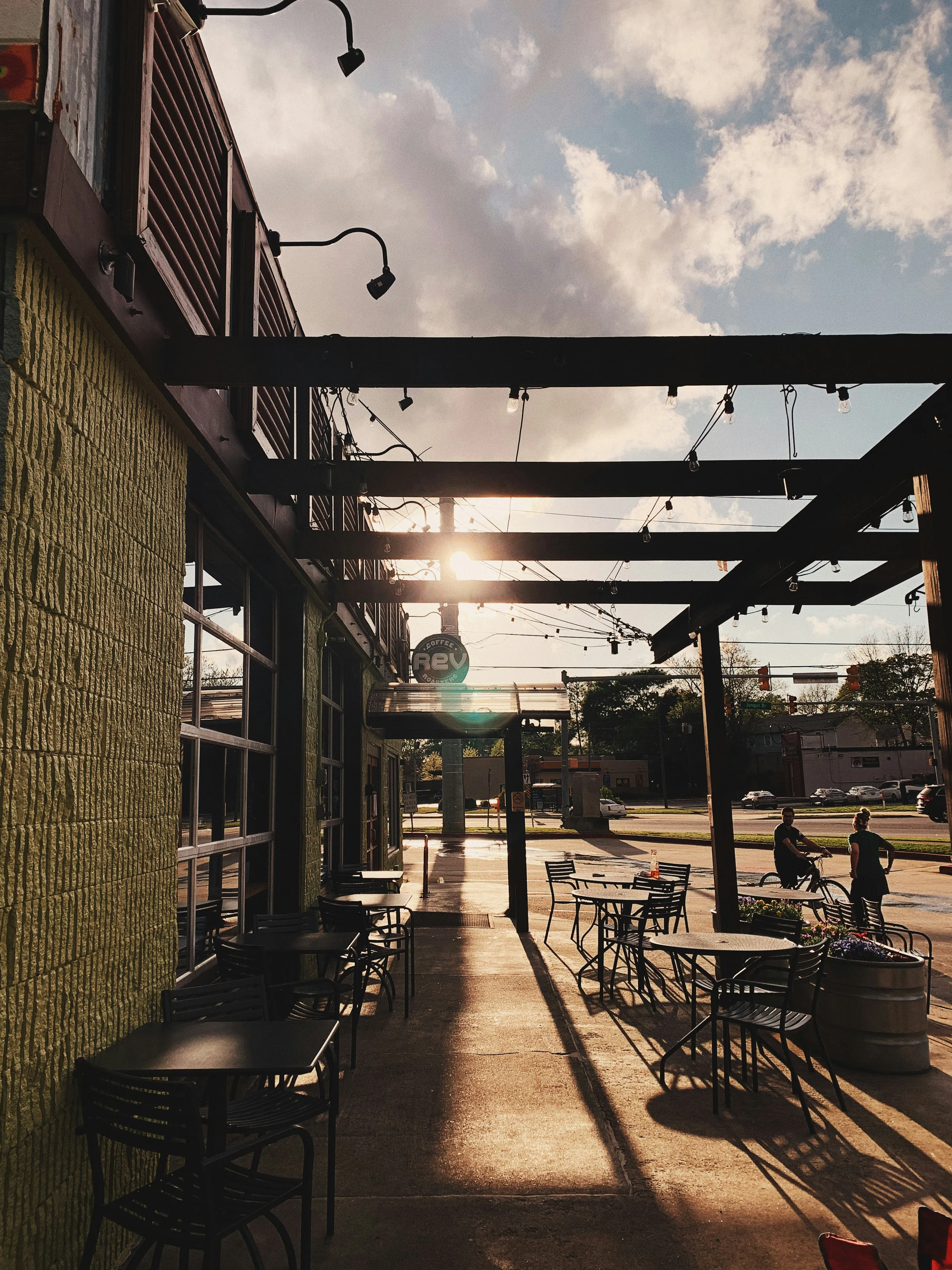 Covered restaurant patio with tables in the evening sun